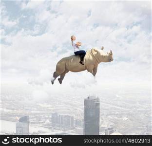 Young pretty fearless woman riding huge flying. Woman flying rhino