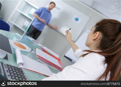 young pretty female college student sitting in a classroom