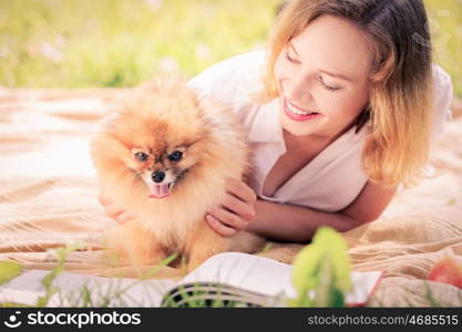 Young pretty girl in summer park with cute dog