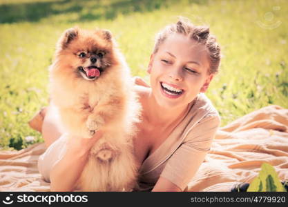 Young pretty girl in summer park with cute dog