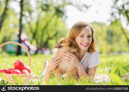 Young pretty girl in summer park with cute dog