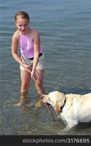 Young pretty girl playing with a dog in lake water