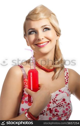 Young pretty girl with color make up hairstyle and color dress drinking from colored bottle some drink, she takes the red bottle with right hand, smile and looks up with dreamy eyes