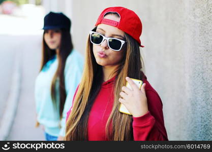 Young pretty girls friends having fun outdoor in autumn sunny evening laughing and going crazy on the street.