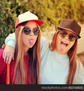 Young pretty girls friends having fun outdoor in autumn sunny evening laughing and going crazy on the street.