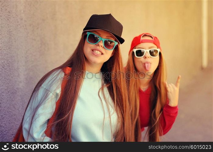 Young pretty girls friends having fun outdoor in autumn sunny evening laughing and going crazy on the street.