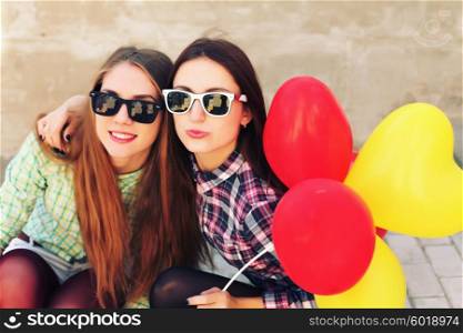 Young pretty hipster girls friends having fun outdoor in summer on the street. Vintage lifestyle trendy portrait.