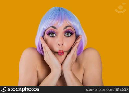 Young pretty model wearing short vivid wig and false eyelashes making fish lips posing at camera. . Playful coquette girl in colorful
