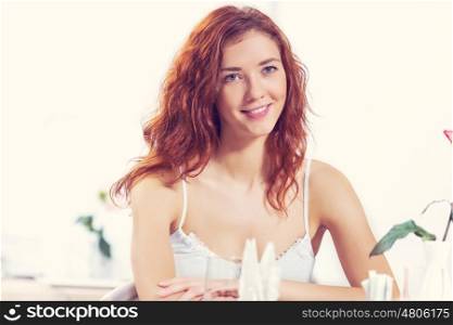 Young pretty red haired woman sitting in cafe. I would like a cup of tea