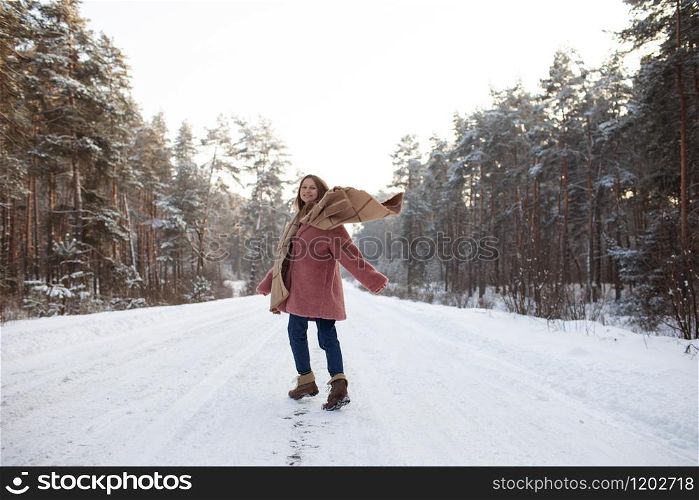 Young pretty stylish woman having fun in the winter snowy forest in motion. Young pretty stylish woman having fun in the winter snowy forest in motion.