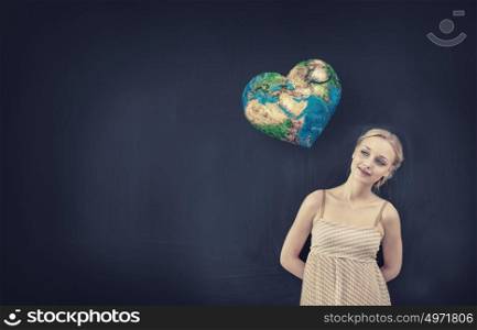 Young pretty woman and heart shaped Earth planet. Elements of this image are furnished by NASA. Back to school