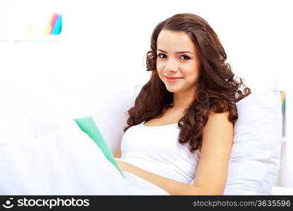 Young pretty woman at home with a book