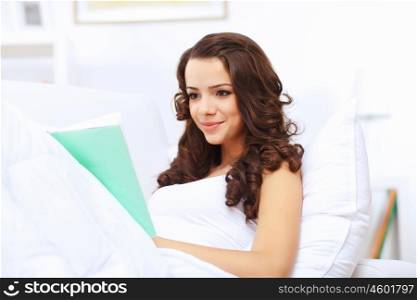 Young pretty woman at home with a book