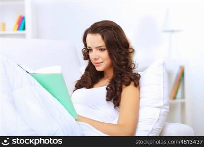 Young pretty woman at home with a book