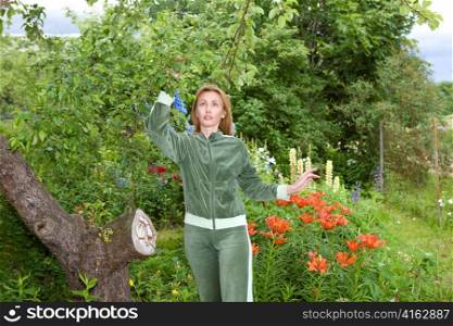 Young pretty woman considers set of fruits on aple tree
