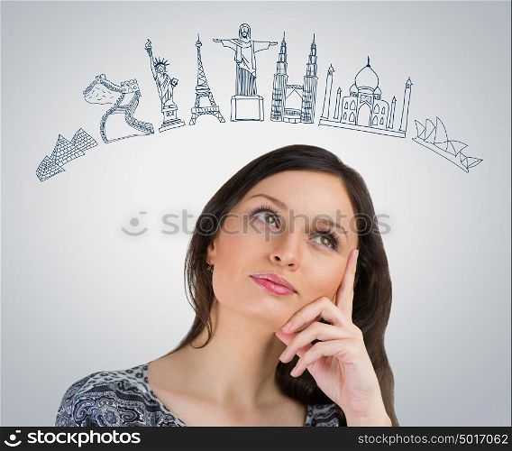 Young pretty woman dreaming about her vacation. Famous touristic destinations symbols are drawn overhead