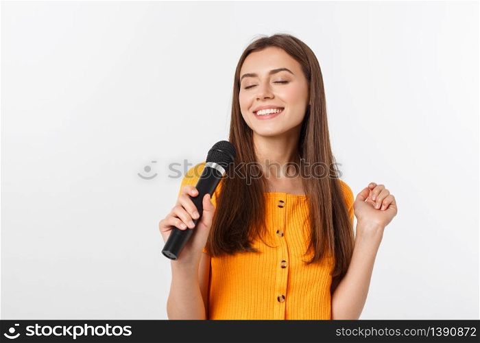 Young pretty woman happy and motivated, singing a song with a microphone, presenting an event or having a party, enjoy the moment.. Young pretty woman happy and motivated, singing a song with a microphone, presenting an event or having a party, enjoy the moment