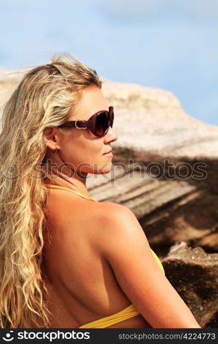 Young pretty woman in bikini and glasses at the beach