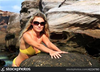 Young pretty woman in bikini and glasses at the beach