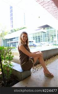 Young pretty woman in brown dress in sitting pose