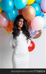 Young pretty woman in white dress with many color balloons on white background. Woman with many color balloons