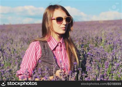 Young pretty woman posing outdoor in the lavender fields. Bohemian style. Blowing long hair. Fashion shooting. Boho-chic.