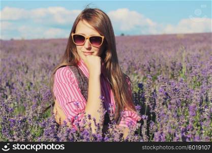Young pretty woman posing outdoor in the lavender fields. Bohemian style. Blowing long hair. Fashion shooting. Boho-chic.