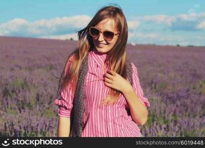 Young pretty woman posing outdoor in the lavender fields. Bohemian style. Blowing long hair. Fashion shooting. Boho-chic.