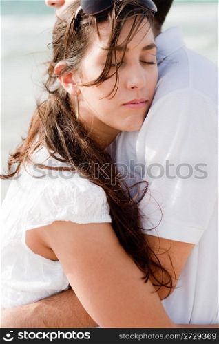 young pretty woman relaxing on her husband shoulders on the beach