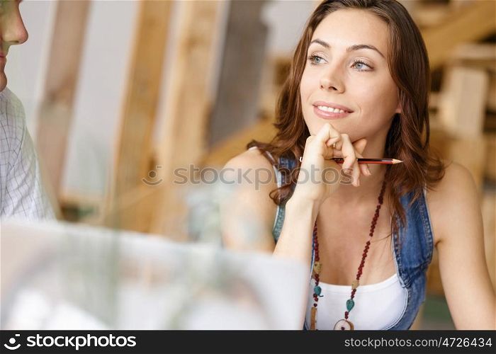 Young pretty woman sitting at her desk. Young pretty woman smiling while sitting at her desk in her office