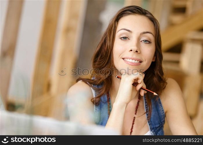 Young pretty woman sitting at her desk. Young pretty woman smiling while sitting at her desk in her office