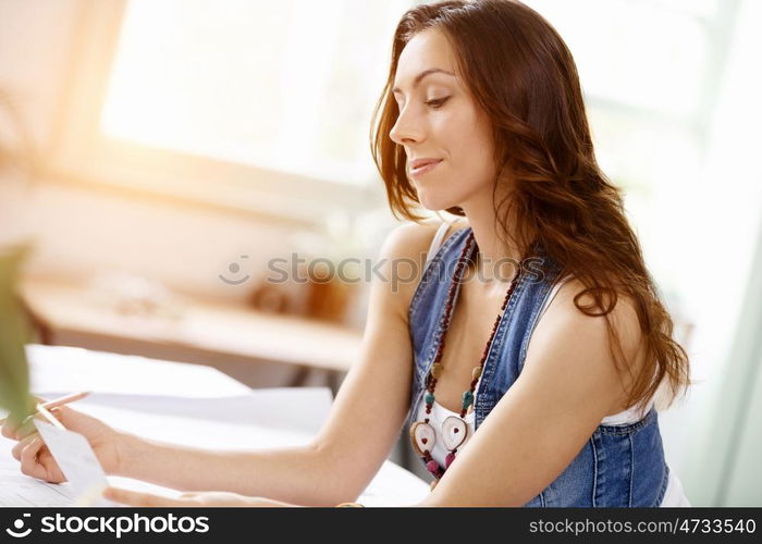 Young pretty woman smiling at her desk in office. Young pretty woman smiling at her desk in her office