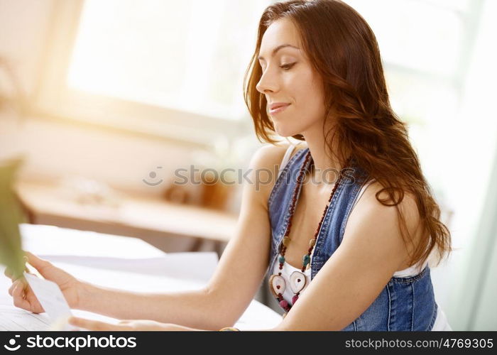 Young pretty woman smiling at her desk in office. Young pretty woman smiling at her desk in her office