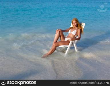 Young pretty woman tans in beach chair