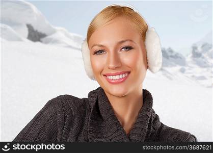 young pretty woman wearing white earmuffs and gray wool sweater be ready to go out in a cold winter day smiling against white background