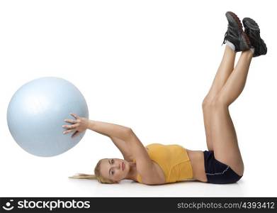 young pretty woman with gym body , doing fitness exercise and keeping a big ball laying down