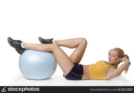 young pretty woman with gym body , doing stretching exercise with ball isolated on white looking in camera