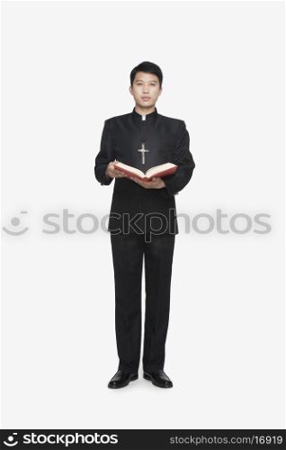 Young Priest Standing with Bible