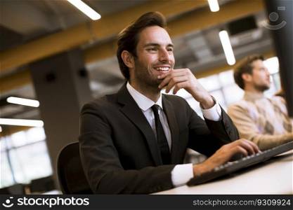 Young professional businessman uses a laptop for work in the office