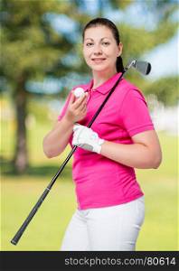 young professional golfer posing on a background of golf courses