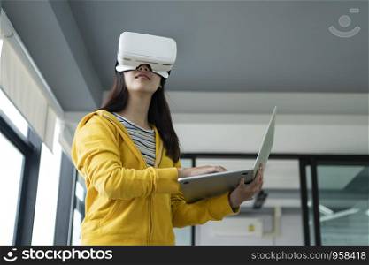 Young programmer or software developer with virtual reality glasses to testing 3D games and application. Technology and software development concept.