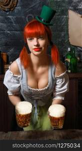 young red-haired Irish waitress in a little leprechaun hat brings two glasses of foamy beer in a St. Patrick?s Day pub