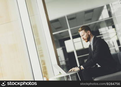 Young redhair man working on laptop in the office