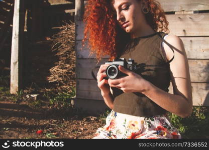 Young redhead photographer woman enjoying her passion outdoors