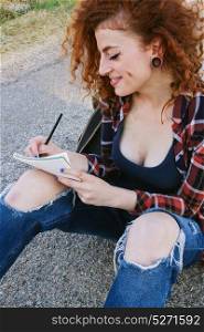 Young redhead student writing in her notebook