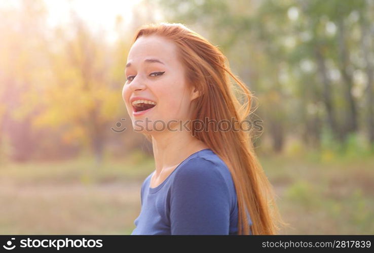 Young redhead woman in the park having fun