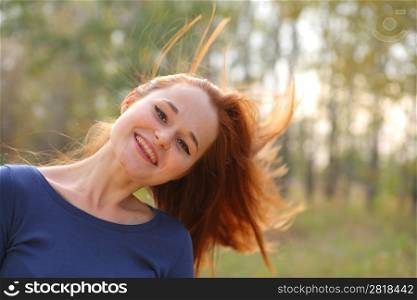 Young redhead woman in the park having fun