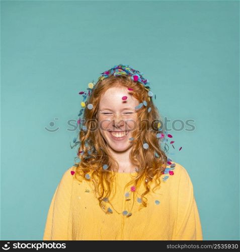young redhead woman partying with confetti her hair