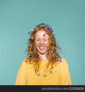 young redhead woman partying with confetti her hair