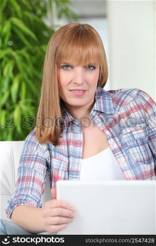 Young redhead woman using laptop at home